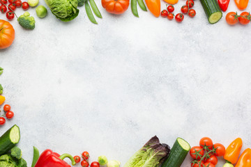 Fresh raw salad ingredients, vegetables tomatoes cucumbers lettuce pepper spring onion broccoli peas on the white table, top view, copy space, selective focus