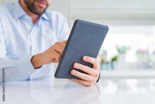 Close up of man hands using tablet and smiling