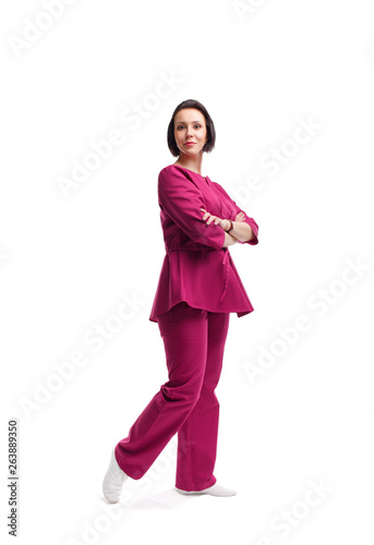 beautiful woman in medical uniform. In full growth on a white background, semi-profile. European brunette. Smiles, confident. Doctor, specialist, nurse.