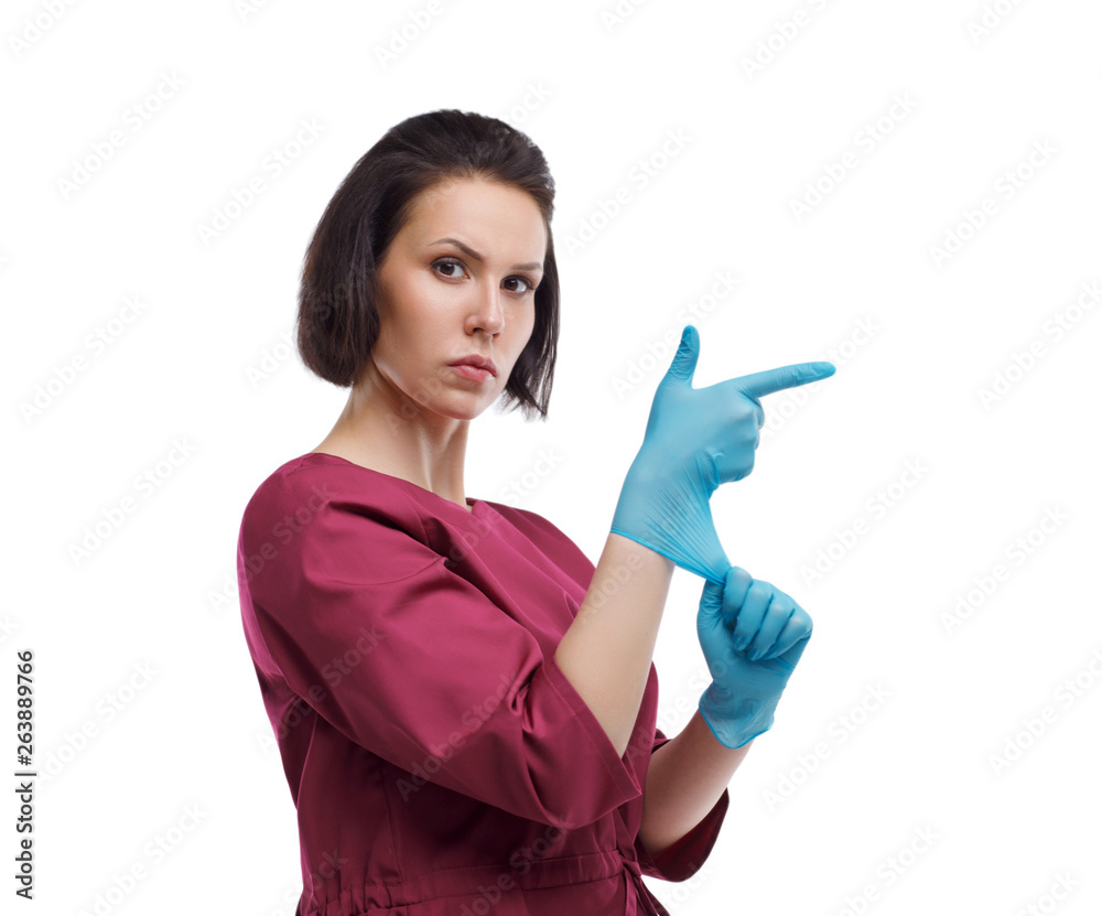 European woman doctor in medical gloves. Woman superman, glove gun. Close-up portrait on a white background. Isolate European woman doctor in medical gloves. Woman superman, glove gun. Close-up portrait on a white background. Isolate