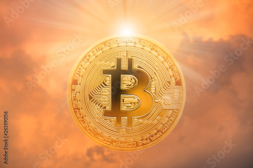 Double exposure of bitcoin with sunlight and dramatic sky