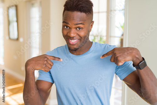Handsome african american man wearing casual t-shirt looking confident with smile on face, pointing oneself with fingers proud and happy.