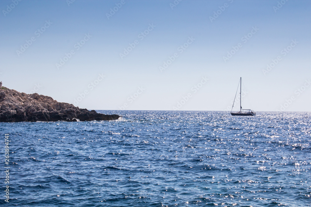Island stone shore and sailing boat