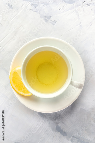 A photo of a cup of green tea with lemon, shot from the top with copy space