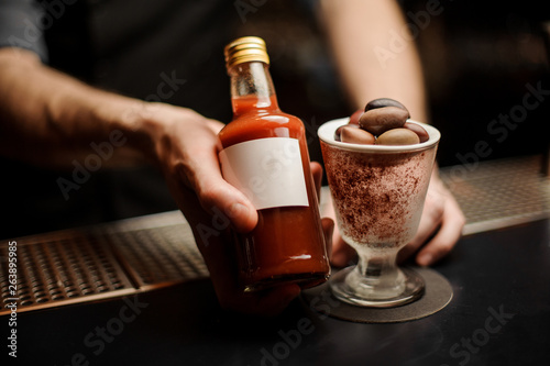 Close-up of bloody mary cocktail bottled in bartender's hands