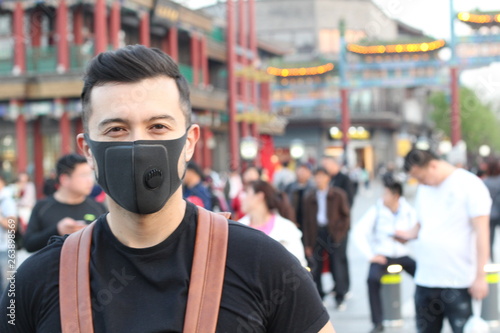 Man with pollution mask standing out from the crowd 