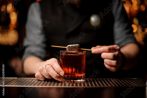 Close shot of an alcohol cocktail with chocolate in bartender's hands