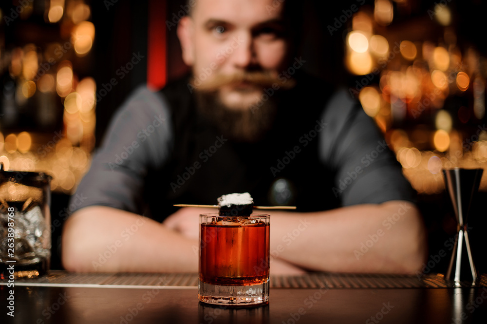 Close-up of alcohol cocktail with bartender on background