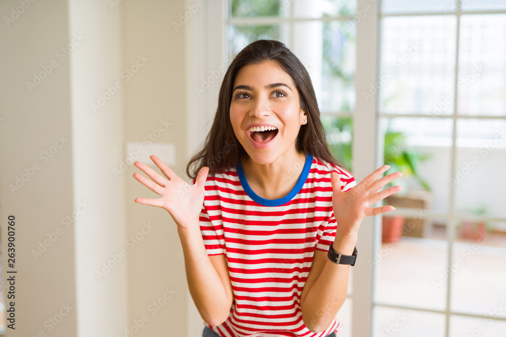 Beautiful young woman celebrating excited for success, screaming and smiling for winning Beautiful young woman celebrating excited for success, screaming and smiling for winning