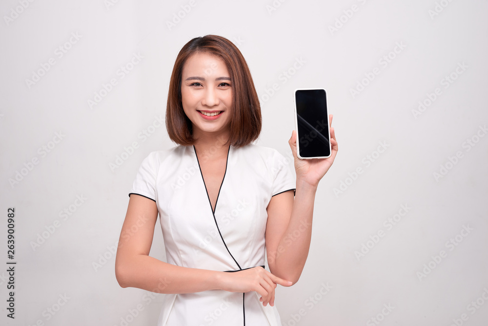 Beautiful Asian woman holding blank screen smartphone on white background Beautiful Asian woman holding blank screen smartphone on white background