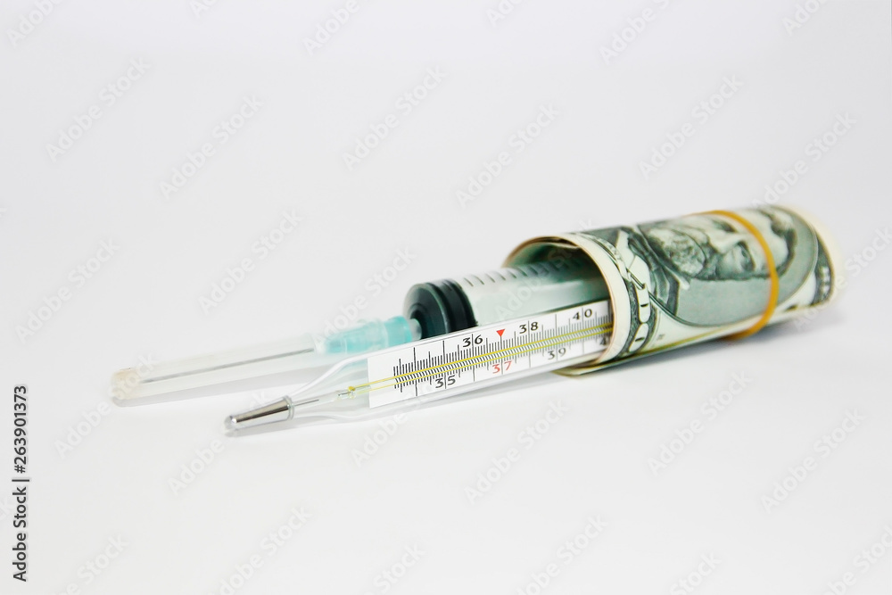 medical syringe and thermometer in a roll of dollars on a white background medical syringe and thermometer in a roll of dollars on a white background