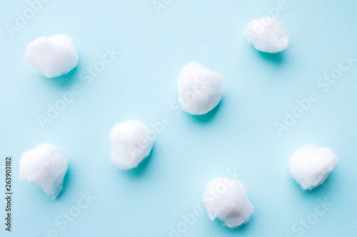 Dentistry concept. Flat lay of teeth like cotton balls on blue surface. Abstract background.