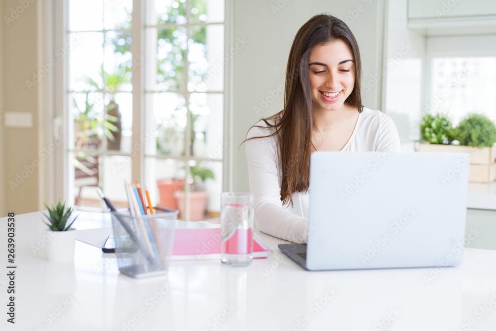 Young beautiful woman smiling happy and working using computer laptop Young beautiful woman smiling happy and working using computer laptop