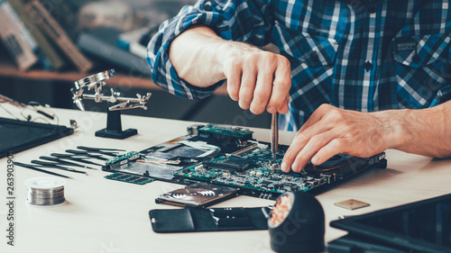 Computer repair technician working on motherboard photo