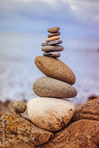 Balance, relaxation and wellness: Stone cairn outside, ocean in the blurry background