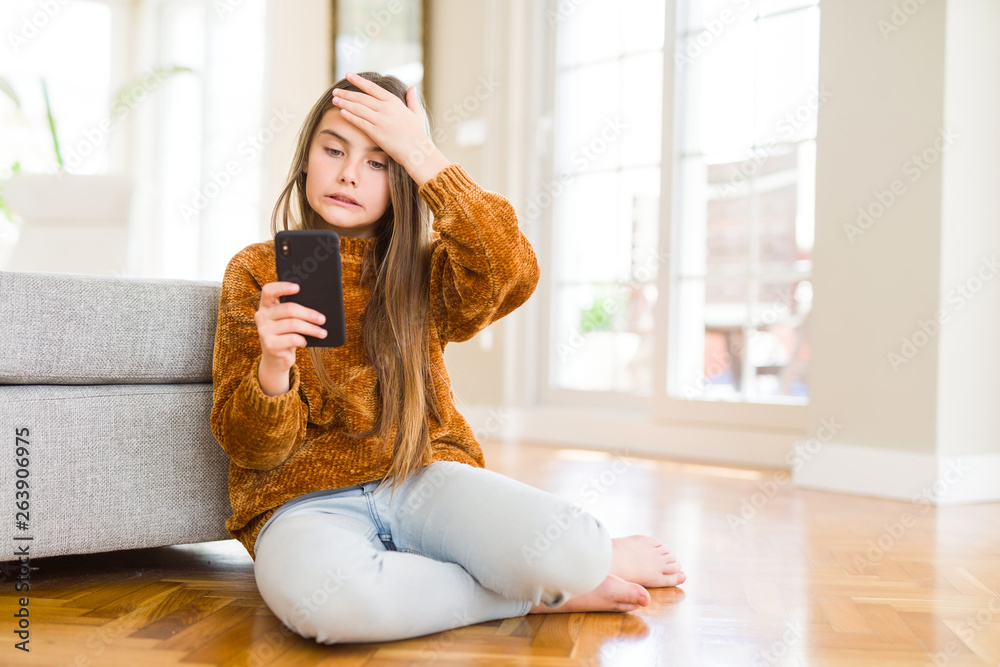 Beautiful young girl kid sending a message using smartphone stressed with hand on head, shocked with shame and surprise face, angry and frustrated. Fear and upset for mistake.