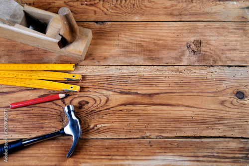 hammer, pencil, jack-plane and folding ruler on wooden background