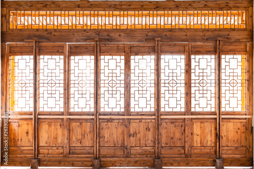 Closeup Chinese old wooden frame door with decorative pattern under the sunshine ,view from inside of building.