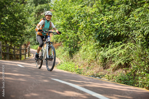 Fototapeta Naklejka Na Ścianę i Meble -  Woman cyclist riding Mountain Bike on forest trail