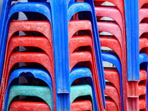 Stack of old plastic chairs of street restaurant in Thailand