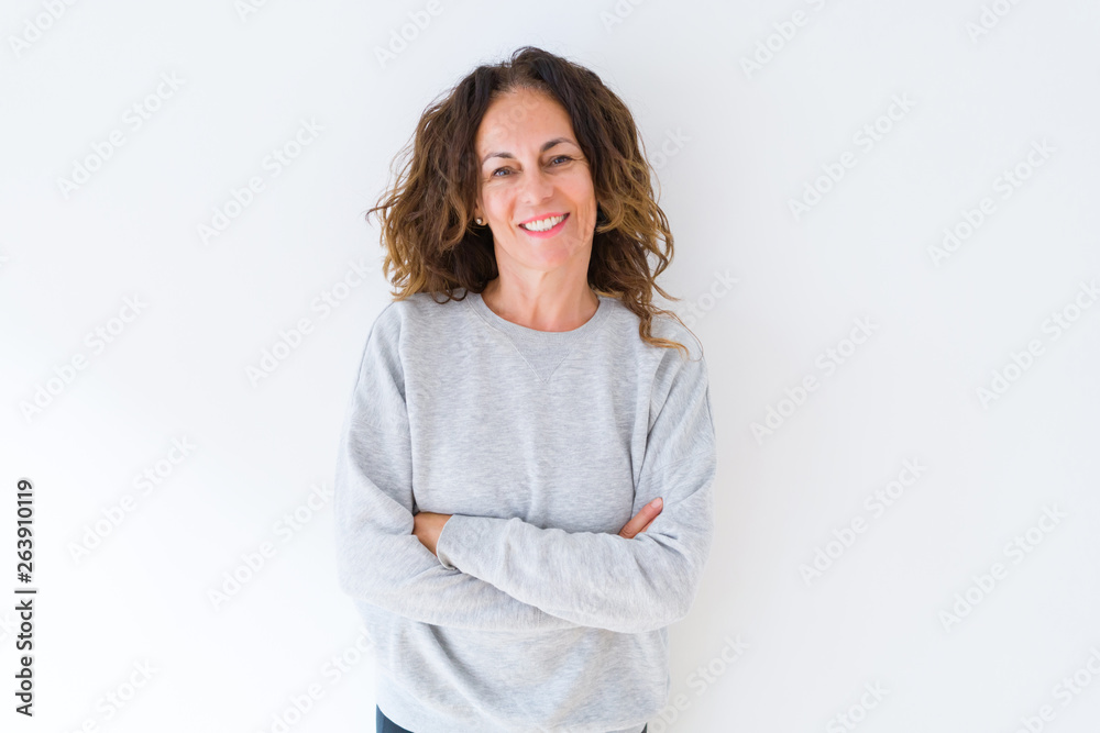 Beautiful middle age woman with curly hair smiling cheerful and happy with arms crossed, laughing with a big smile on face showing teeth over white isolated background Beautiful middle age woman with curly hair smiling cheerful and happy with arms crossed, laughing with a big smile on face showing teeth over white isolated background