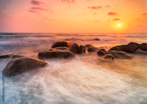 Beautiful natural seascape wave hit the rock during sunset