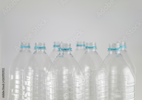 Bottlenecks of a pack of liter and a half of empty mineral water without caps just with the sealing ring on a white background. Reuse, Eco-Friendly, Environment, Conservation, Sustainable.