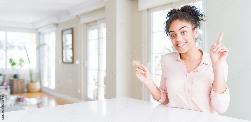 Wide angle of beautiful african american woman with afro hair smiling confident pointing with fingers to different directions. Copy space for advertisement Wide angle of beautiful african american woman with afro hair smiling confident pointing with fingers to different directions. Copy space for advertisement