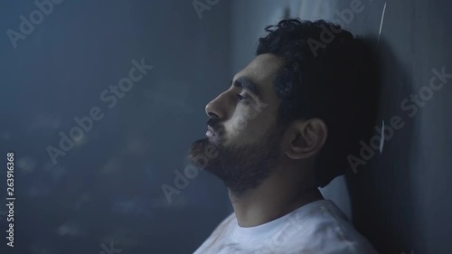 A sad oppressed young man in prison