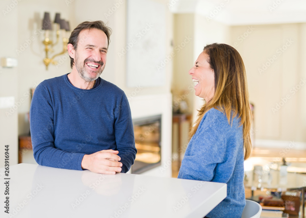 Romantic middle age couple sitting together at home Romantic middle age couple sitting together at home