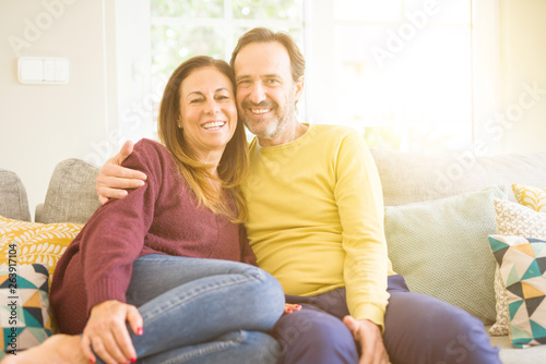 Middle age romantic couple sitting on the sofa at home