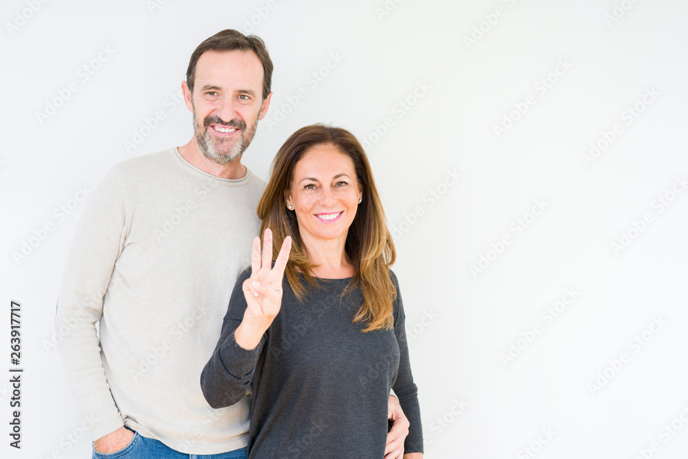 Beautiful middle age couple in love over isolated background showing and pointing up with fingers number three while smiling confident and happy. Beautiful middle age couple in love over isolated background showing and pointing up with fingers number three while smiling confident and happy.