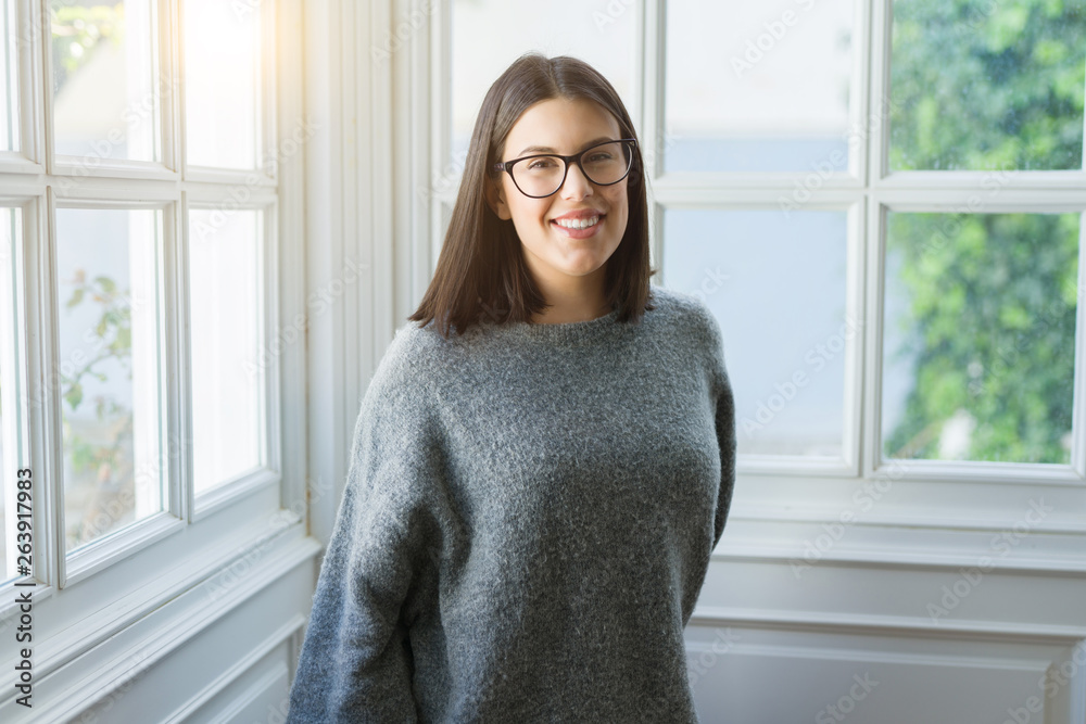 Young beautiful woman wearing glasses smiling cheerful standing casual at home on a sunny day Young beautiful woman wearing glasses smiling cheerful standing casual at home on a sunny day