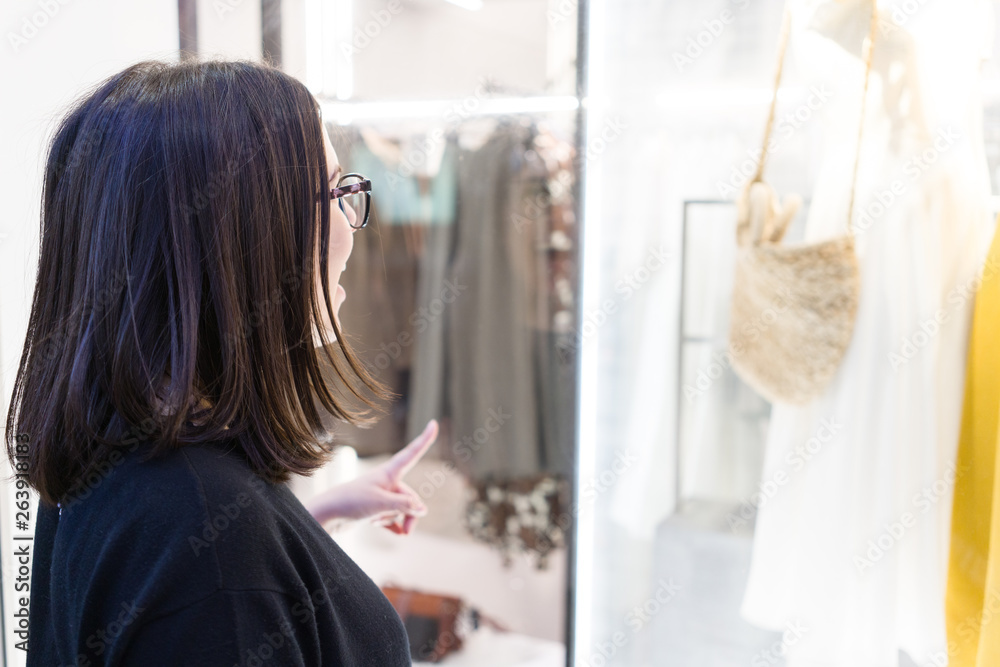 Beautiful young woman looking store showcase in love with clothes, pointing glass smiling and happy at the shopping center Beautiful young woman looking store showcase in love with clothes, pointing glass smiling and happy at the shopping center