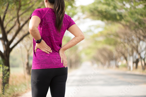 Tired Young asian Sport girl feel pain on her back and hip while exercising, health care concept.