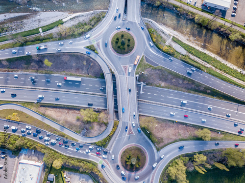 Highway interchange junction with traffic aerial top down view photography from drone with vehicles driving on freeway, roundabout and ramp lanes, transportation from above