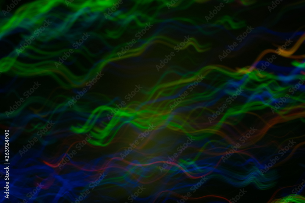 Blur multicolor wavy lines on dark background. Neon lights in motion. Bokeh lens flare glow.
