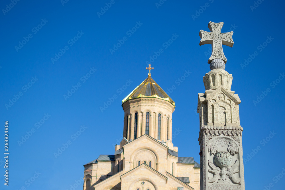 Religious cross on the background of Tsminda Sameba or The Holy Trinity Cathedral of Tbilisi, Georgia in clear weather