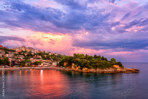Panoramic view of Ulcinj and Jadran peninsula at sunset, beautiful mediterranean town, popular summer tourist resort in Montenegro, scenic travel background with amazing colorful cloudy sky