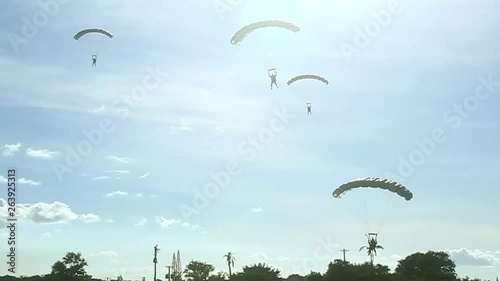 Soldiers arriving by parachute in an open field 3