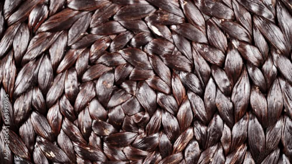 Dark brown wicker woven pattern rotating. Abstract background or texture. Top down view Dark brown wicker woven pattern rotating. Abstract background or texture. Top down view