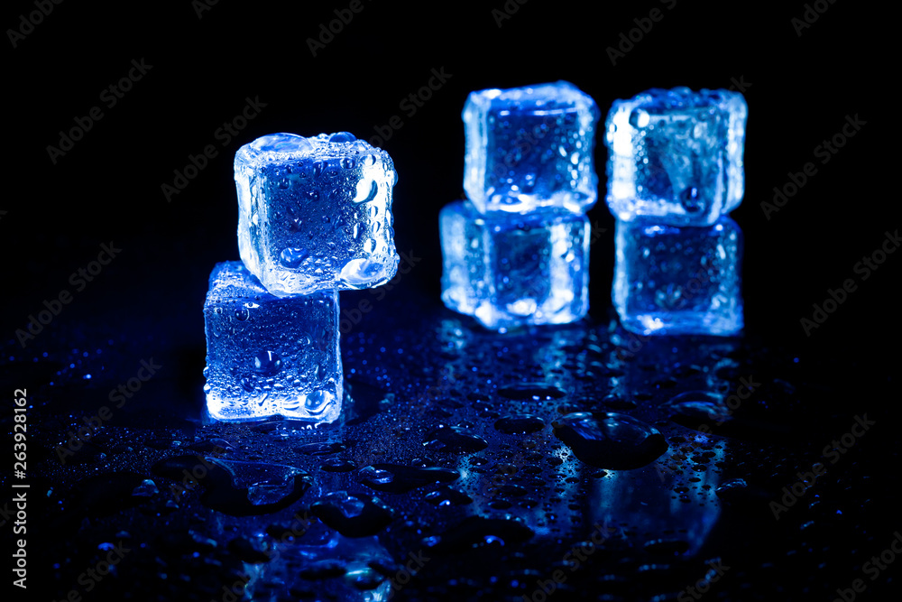 Blue ice cubes reflection on black table background. Blue ice cubes reflection on black table background.