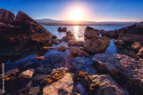 Amazing nature seascape with rising sun over the rocky seacoast of Akamas peninsula, Cyprus. Mediterranean sea near the popular Lara beach tourist location, travel background