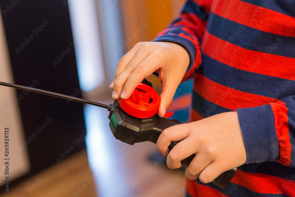 child playing with a wheelchair with a remote at home. radio controlled car toy for children. Boy with joystick plays with a toy car at home. child playing with a wheelchair with a remote at home. radio controlled car toy for children. Boy with joystick plays with a toy car at home.