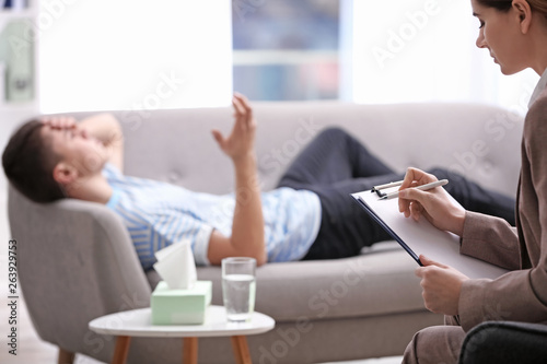 Psychotherapist working with young man in office