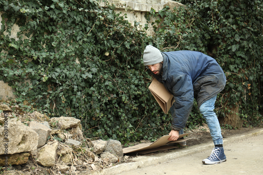 Poor homeless man with cardboard on street Poor homeless man with cardboard on street