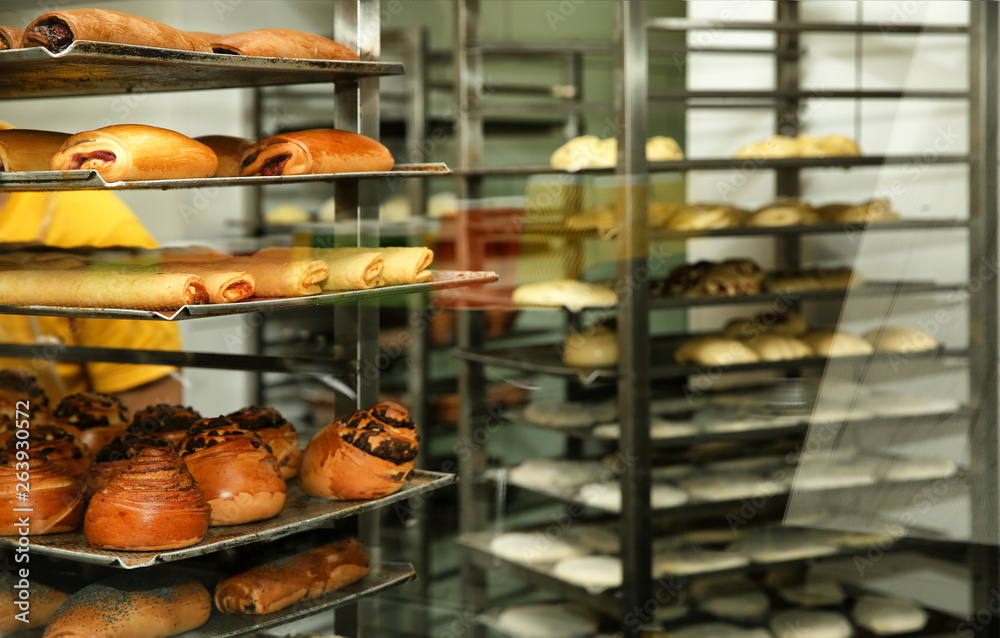 Rack with fresh pastries in bakery workshop