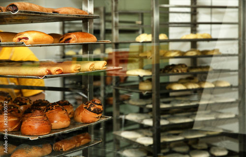 Rack with fresh pastries in bakery workshop