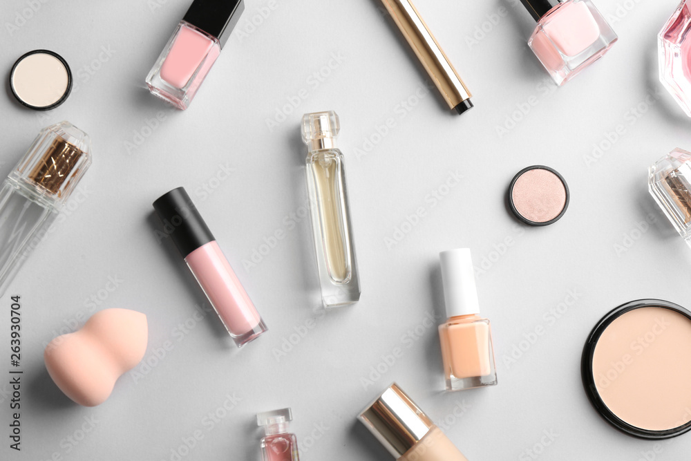 Flat lay composition with bottles of perfume and cosmetics on grey background Flat lay composition with bottles of perfume and cosmetics on grey background
