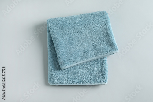 Fresh fluffy folded towel on grey background, top view. Mockup for design